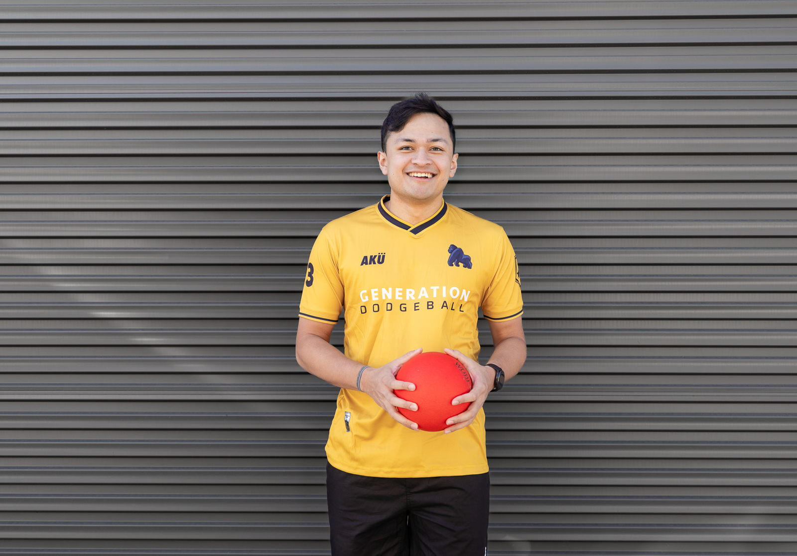 Dodgeball player with bear logo jersey holding red dodgeball