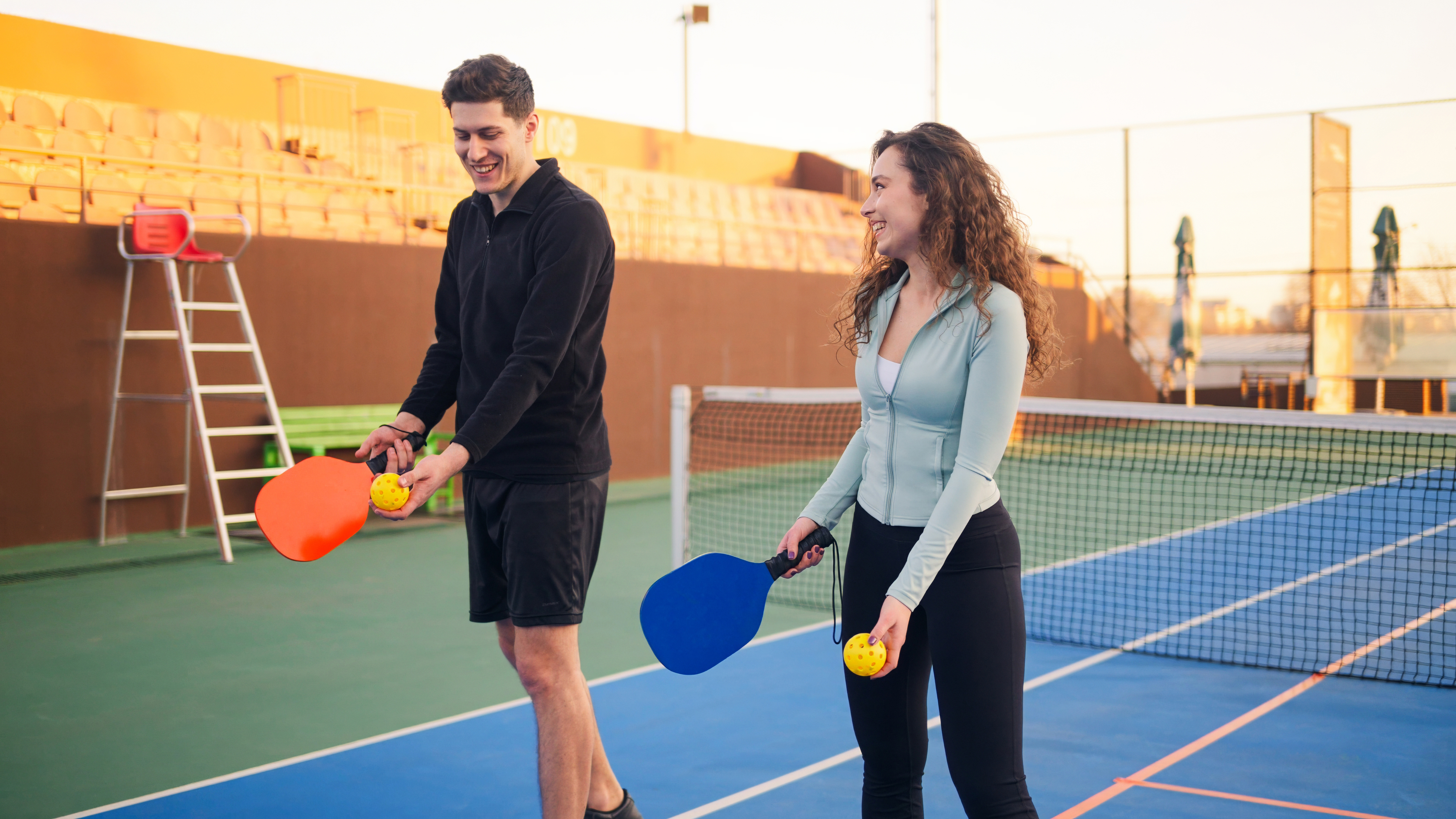 Diverse group of pickleball players of different ages celebrating together after a fun match